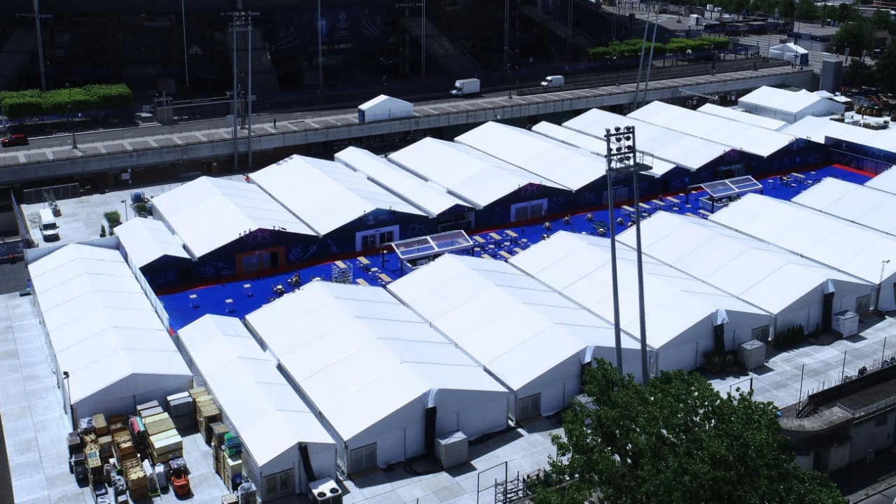 A clear-span hangar structure seen from above at dusk.